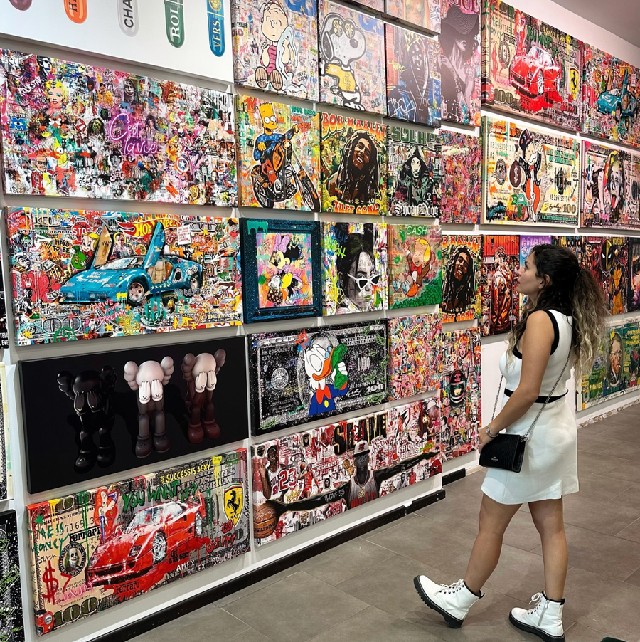 Customer browsing the wall of canvases in an Urban Customz store
