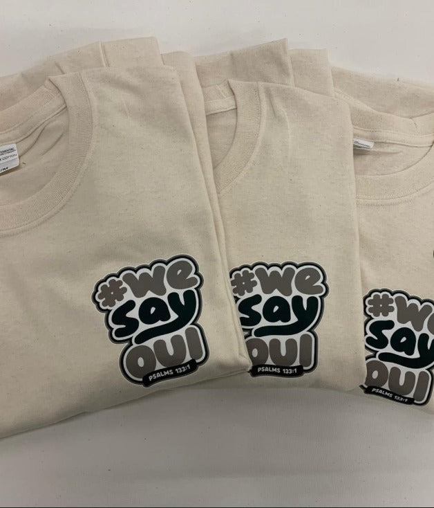 Folded natural-colour t-shirts printed with an event design